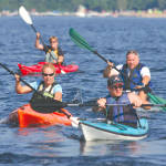 PADDLING IN TIGHT RANK â€” Competitors squeezed closer together as they approached a turn marker on Moose Pond during the first leg of the Great Adventure Challenge triathlon, benefitting Good Neighbors, Inc. (Rivet Photo)