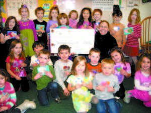 After a month of making Valentines cards and selling them for 10 cents each, two kindergarten classes raised $296 to help out animals. On Friday, the students, who attend Songo Locks Elementary School, presented a check to Joan McBurnie, the executive director of Harvest Hills Animal Shelter. (De Busk Photo)   
