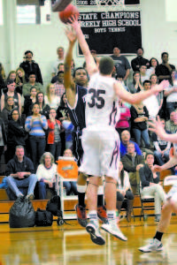 JAQUAN CAUSER has hits baseline shot tipped by Greely's 6-foot-7 center Mike McDevitt during Tuesday's playoff game. (Rivet Photo)