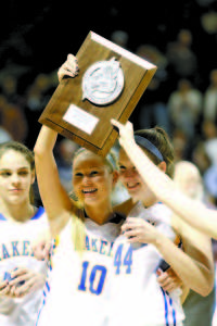 MORE HARDWARE FOR THE TROPHY CASE â€” Seniors Kari Eldridge and Kate Cutting hold up the runner-up plaque before the Lake Region crowd, as teammate Lucy Fowler (left) looks on.