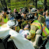 A SURVIVOR of the crash is removed from the vehicle by emergency personnel.