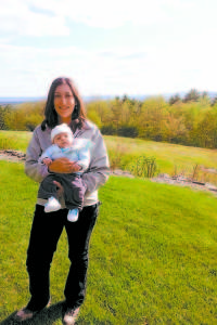 Loon Echo Land Trust Executive Director Carrie Walia enjoys the view from Hackerâ€™s Hill in mid-May while her two-month-old son, Grayden, rides along in a front pack. (Photo Courtesy of Carrie Walia) 