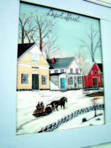 STILL STANDING â€” A section of mural by Nelle Ely shows the buildings of Depot Street of long ago, including the GAR Hall, left, now used by the Bridgton Arts & Crafts Guild. This summer the town will be installing long-awaited sidewalks and curbing on Depot Street, in a first step toward the streetâ€™s revitalization. 