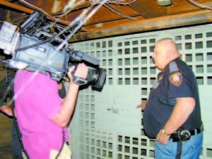 BAD MEMORY CELLS â€” Bridgton Police Lt. Peter Madura shows a CBS film crew the two steel jail cells in the basement of the Oberg building at 48 Main Street, which once housed the Bridgton Police Department. CBS Entertainment spent all day Friday filming in downtown Bridgton to show its viewers the real-life locations that inspired Stephen Kingâ€™s Under the Dome, which premieres as a TV series at 10 p.m. Monday, June 24 on CBS. (Geraghty Photo)
