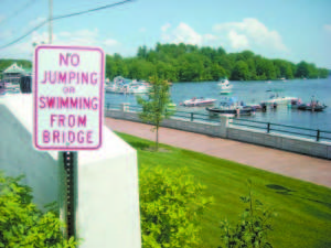 POSTED â€” This posted sign has not deterred preteen children from jumping off the railing below the bridge â€” an activity that concerns Naples Harbor Master Bill Callahan. â€œI am concerned about them getting hit by a boat. Someone could really get injured or worse. The person who hits a person in the water would feel like heck, and have to live with that for the rest of their lives,â€ Callahan said. (De Busk Photo) 