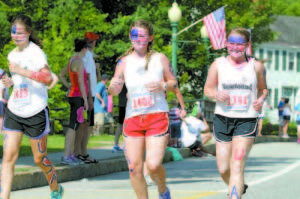 FEELING PATRIOTIC — Camp Newfound teens (left to right) Rebecca Tozzi, Lucy Jane Hurley and Montana Hayes sported red, white and blue face make-up as part of their Bridgton 4 on the Fourth race attire.