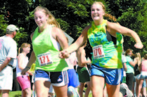 HAND IN HAND â€” Heading toward the finish line are Sierra Leavitt (left) and Kristina Morton, both of Naples,