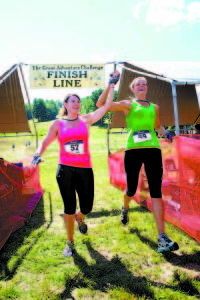 HAPPY FINISHERS Kelley St. Hilaire (left) and Marcey Crosskill raise their arms in triumph.