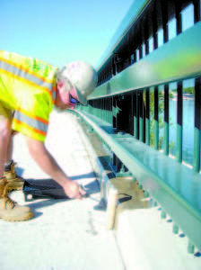 A crew applies a protective sealant onto the surface of the Bay of Naples Bridge on Wednesday morning. (De Busk Photo)     