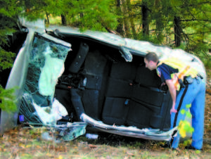  INVESTIGATION BEGINS â€” Bridgton Police Officer Phil Jones peers inside the wreckage of a 2010 Kia Friday after its five occupants, including two juveniles, were taken by ambulance to Bridgton Hospital. Extrication units from Bridgton and Naples Fire Departments were used to remove the roof. The occupants were three females, ages 20, 19 and under 18, and two males, ages 20 and under 18. 