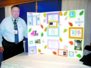 Casco Town Manager Dave Morton stands next to a poster promoting the Casco Public Library. On Tuesday, the Town of Casco staff and selectmen manned an informational booth at the Sebago Lakes Region Chamber of Commerce’s Sebago Summit Trade Show held at Saint Joseph’s College. (De Busk Photo)