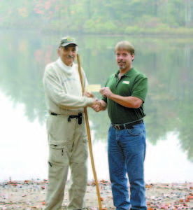 A GIFT â€”  Bridgton resident Bob Casimiro presents $1,000 to Loon Echo Land Trustâ€™s Volunteer and Stewardship Coordinator Jon Evans. The monetary gift is for the Perley Mills Community Forest fundraising campaign. (Photo courtesy of Loon Echo Land Trust)  
