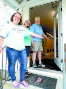 VILLAGE STORE OPENS DOORS â€” (From left to right) Jennifer Morgan, Kay Mahoney and owner Evelyn Meserve gesture to the open door of Casco Village Variety, which had a soft opening over the weekend. The remodeled store is located off Route 121 in the building of the former AG Store. (De Busk Photo) 