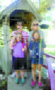 (From left to right) Cathy McIntire, of Portland, poses with her granddaughter, Kate Pelleiter, 9, of Gorham, while Judy Murphy stands behind her granddaughter, Abbie Bouse, 8, of Yarmouth. The group was enjoying a game at Steamboat Landing Miniature Golf on Tuesday. (De Busk Photo) 