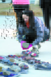 UNLOADING THE MEMORY STONES â€” Lake Region High School teacher Carmel Collins remove memorial stones as part of the Summit Project in front of the high school before Sunday's hike of Pleasant Mountain. (Rivet Photo)