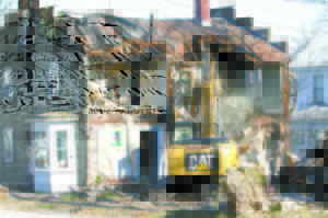 RIPPED APART — A Ward Excavation worker demolishes the back portion of the former Sportshaus building Tuesday afternoon. As the building was torn down, many spectators stopped to watch and take photos. (Rivet Photos)