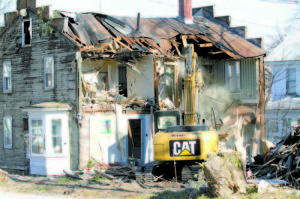 RIPPED APART â€” A Ward Excavation worker demolishes the back portion of the former Sportshaus building Tuesday afternoon. As the building was torn down, many spectators stopped to watch and take photos. (Rivet Photos)