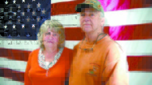 Pauline and Bernard Willey, of Casco, stand in front of an American Flag on Veterans Day. The Vietnam War veteran and his wife plan to take part in â€œWreaths across Americaâ€ in early December. (De Busk Photo)