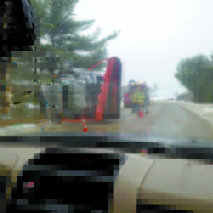 SLIDING SAND TRUCK — A Bridgton Public Works Department sand/plow truck lies on its side on South High Street following Monday’s rollover. (Photo courtesy WCSH-TV News)