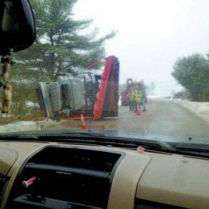 SLIDING SAND TRUCK â€” A Bridgton Public Works Department sand/plow truck lies on its side on South High Street following Mondayâ€™s rollover.  (Photo courtesy WCSH-TV News) 