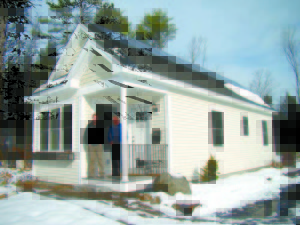CRITERION DEVELOPMENT PARTNERS Justin McIver, left, and Mark Lopez stand at the entrance to the 600-square-foot mini home on Portland Road that served as the test model for the 60-unit Cottages on Willett Brook, on South High Street in Bridgton. 