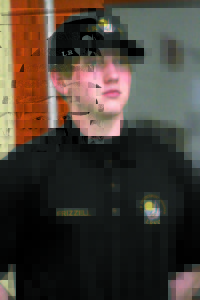 DUSTIN FRIZZELL, a student enrolled in the LRVC law enforcement program, stands at attention while instructor Shawn McDermott makes a presentation before the SAD 61 School Board Monday night. (Rivet Photo)
