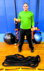 PUMP IT UP â€” Bridgton Rec Director Gary Colello poses with the workout equipment used at a new free fitness-training program at Town Hall on Tuesdays called Project SWEAT. As a trained fitness instructor, Colello provides individual guidance to participants in using the weights, ropes, TRX straps, agility ladder and Bosu Balls in order to strengthen specific muscle groups. (Geraghty Photo)
