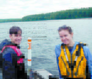 TEMPERATURE BUOY in Moose Pond. Colin Holme and Amanda Pratt in front of one of the buoys marking in-lake temperature sensors in Moose Pond. 