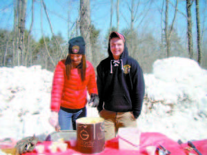 SERVED UP COLD â€” Katherine Cosgrove, 22, originally from Casco, and Cody Moen, 20, of Casco, helped to serve ice cream topped with maple syrup to the people who visited Sweet Williamâ€™s during Maine Maple Sunday. (De Busk Photo) 