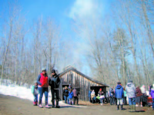 MEET ME â€” at the Sugar Shack, baby! The steam was from boiling water since daytime temperatures during late February and March have been too cold to produce enough sap to make maple syrup. (De Busk Photo) 