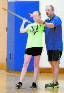 POINTING THE WAY â€” Track & Field Coach Dana Caron works with Hannah Chadwick on javelin technique. (Rivet Photo)