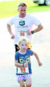 Isabella Sykes, age 7, and David Sykes head for the home stretch,