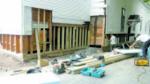 BARE TO THE BONES â€” Workers from Doten Construction were adding rigid insulation Monday between the exposed framing on the rear of Bridgton Town Hall, after spending the first week shoring up deterioration in the foundation involving the entire rear half of the North High Street building. The building had to be jacked up slightly to level the floor space in the hallâ€™s storage area and replace the deteriorated portions of the foundation. The workers say the damage was worse than they had anticipated, but that it should not result in added costs or delays to the project.   (Geraghty Photo) 