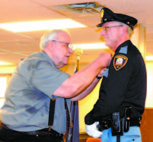 BEING PINNED â€” Bridgton Police Chief Richard Stillman received his Police Chief lapel pin at Mondayâ€™s swearing-in ceremony from his father-in-law, Peter Oâ€™Brien. (Geraghty Photo) 