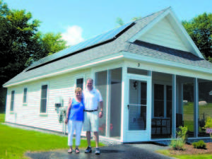 HOME IS WHERE THE HEART IS â€” With Main EcoHomes President Justin McIver, Barbara Gunville, formerly of Cohasset, Mass., says she especially loves the screened-in porch of her 640 square foot home at The Cottages at Willett Brook in Bridgton. Best of all, she says, is that now sheâ€™ll be living close to her four children and their families in Maine.  3 JUSTIN AND BARBARA stand in front of her new home, showing the solar panels on the roof that will reduce her utility costs to close to net zero.  