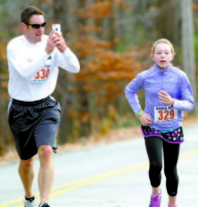 CAPTURING THE MOMENT â€” Chris Lanoue of Scarborough photographs or videotapes Addison Lanoue, age 11, as she approaches the finish line.