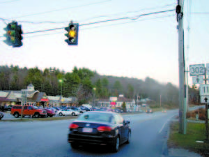 THE TRAFFIC SIGNAL on Roosevelt Trail at the Route 35 junction offers drivers an orange blinking light â€” caution â€” as a nearly full moon rises in the east. (De Busk Photo) 