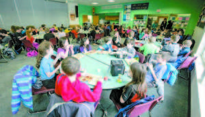LUNCH IN SHIFTS at Songo Locks School includes five lunch periods from 11 a.m. to 1:30 p.m. Lunches and recess dictate the schedule. During winter, many students attend lunch in their snow gear because lunch runs into recess. (Photos by Kevin Muphy)