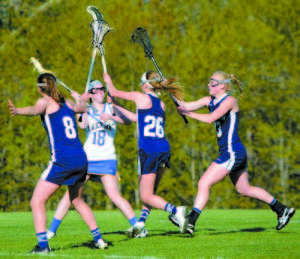 SURROUNDED BY CLIPPERS â€” Lake Region's Lindsey Keenan looks for help as she is surrounded by Yarmouth players during recent girls' varsity lacrosse action. (Photo by Dena Dunn)