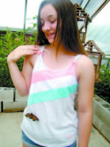 HESITANT BUT DELIGHTED â€”Danielle Gordon, 13, of Casco, decided to let a butterfly crawl on her shirt instead of allowing it to lick nectar from her finger. People can feed monarchs at the Butterfly Pavilion, which is open from 10 a.m. to 5 p.m. daily, at Markâ€™s Lawn and Garden. (De Busk Photo)