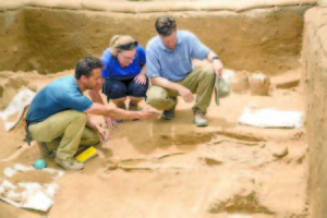 WORKING A DIG SITE in Ashkelon, Israel is senior staff Adam Aja (left, a Lake Region graduate and former Bridgton resident), Sherry Fox and Daniel Master discuss a 10th-9th century BC burial in the excavation of the Philistine cemetery by the Leon Levy Expedition to Ashkelon. (Photo by Tsafrir Abayov)