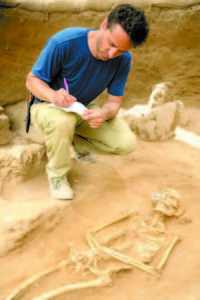ADAM AJA examines skeletal remains discovered during the Ashkelon excavation. (Photo by Tsafrir Abayov)