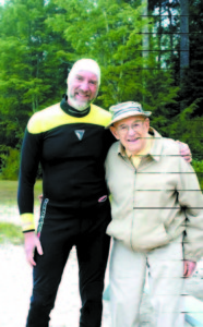 ROLE MODEL for water conservation â€” In 2006, Ron Burd (at left) poses with Joel Bloom, the founder of the Pleasant Lake-Parker Pond Lake Association. In 2016, at age 70, Burd will once again swim the length of Pleasant Lake to raise money for the dam replacement. (Photo courtesy of Ron Burd)