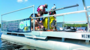 LEA's Colin Holme, Peter Lowell and Amanda Pratt prep Long Lake's new automated testing buoy before deployment